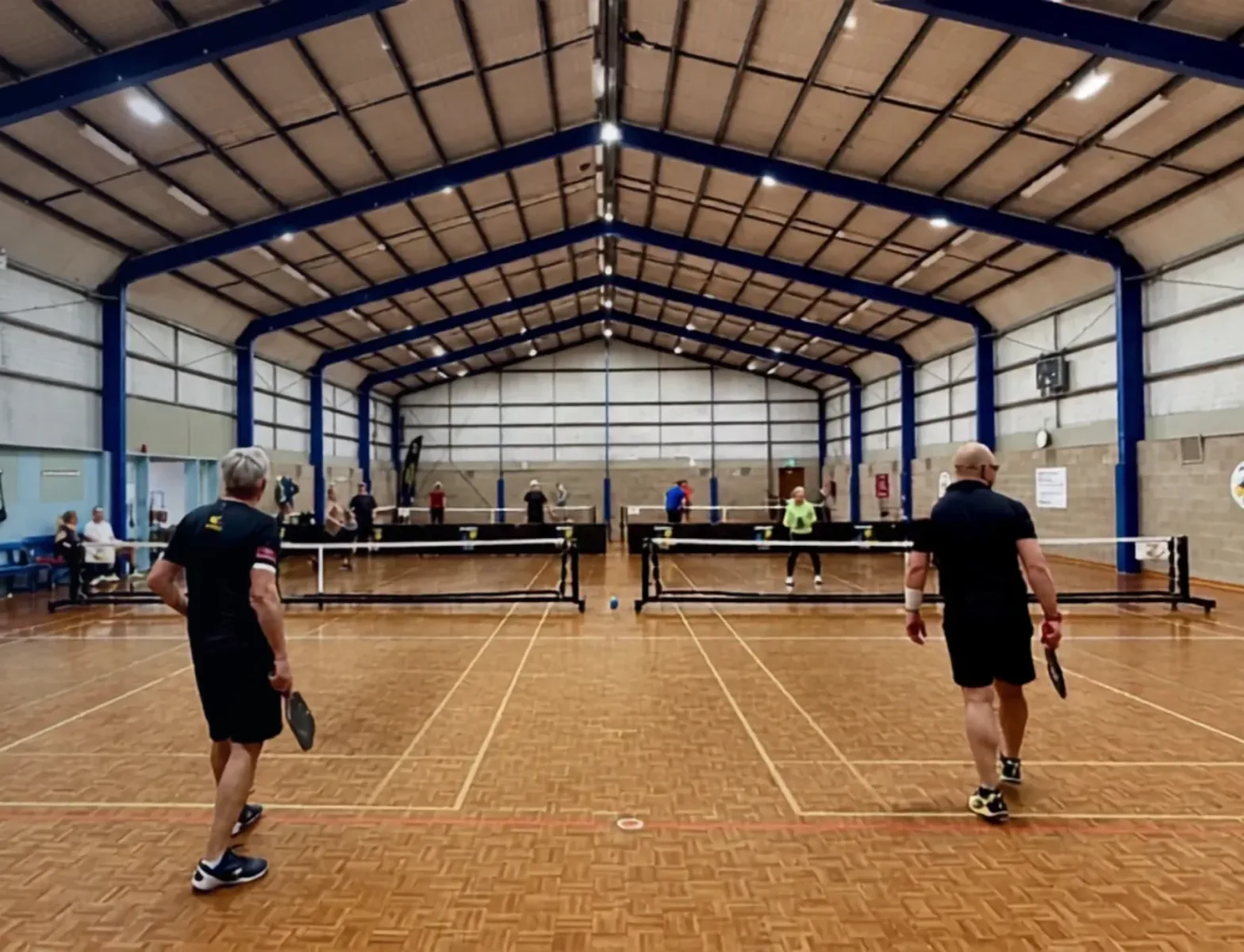 Two players on an indoor court at Bayside Pickleball Club